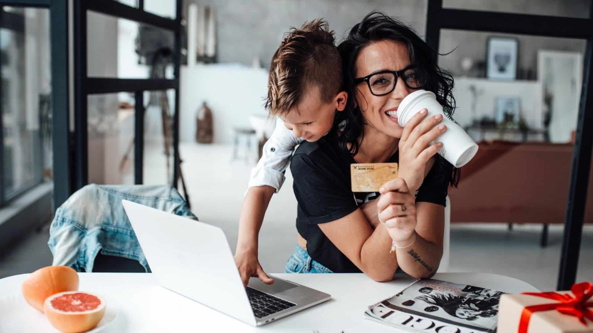 mom holding up credit card smiling with child