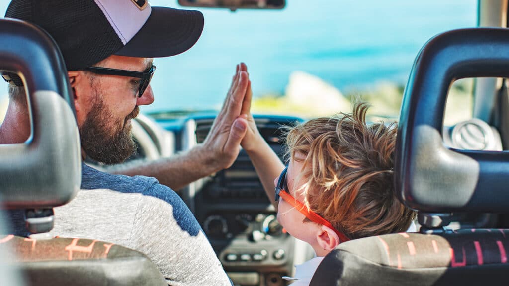 father and son high five in a car