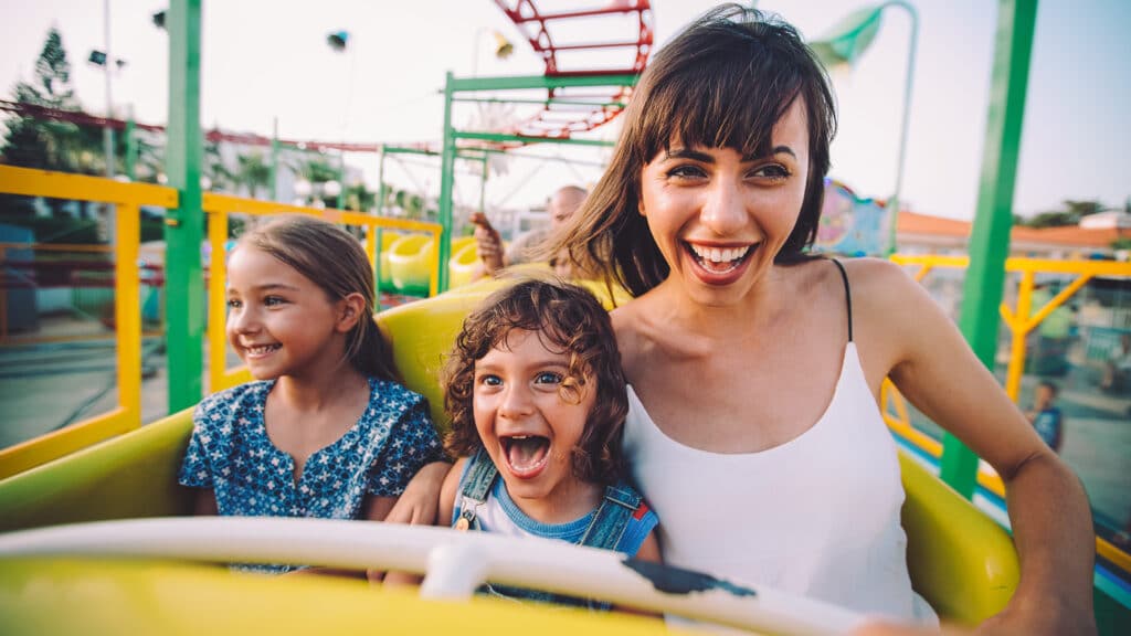 woman and children laughing on a roller coaster