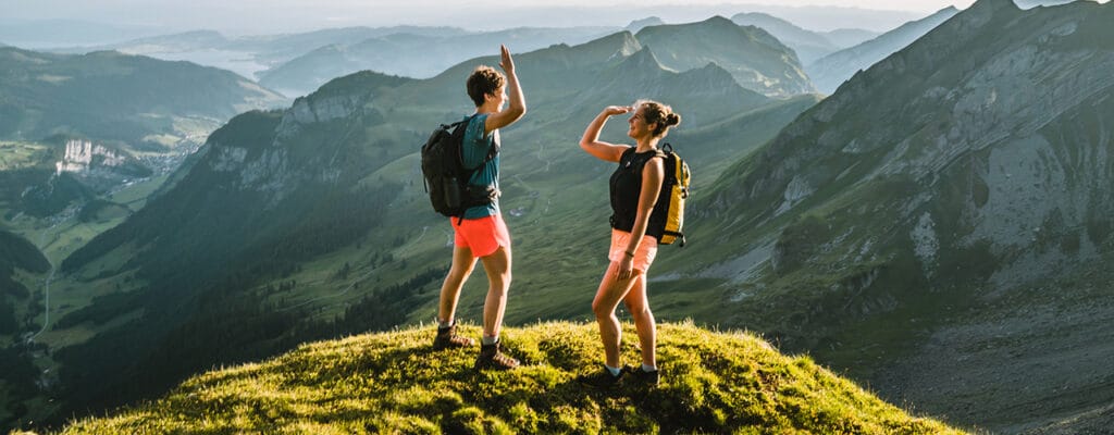 couple high fiving on top of mountain