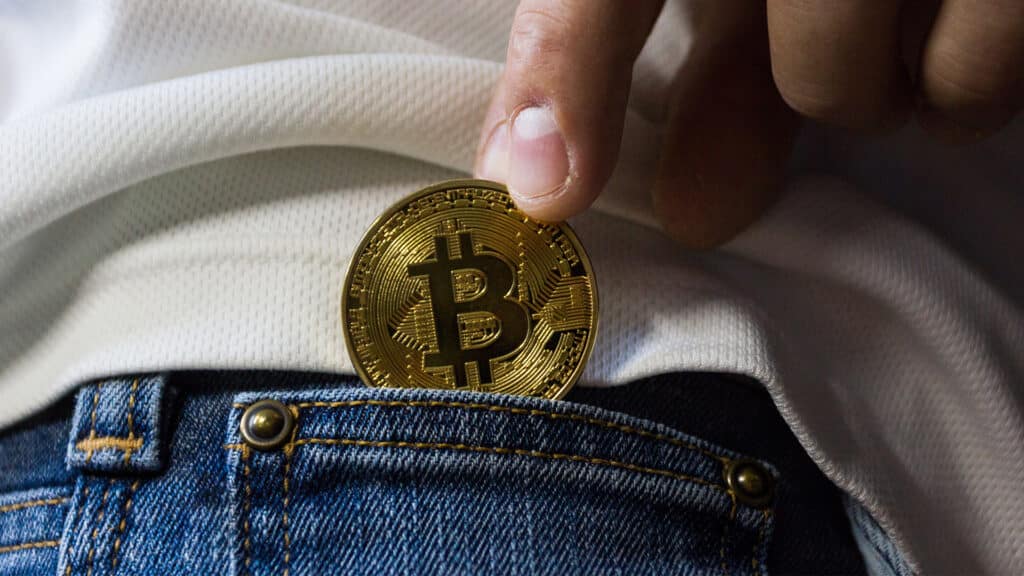 hand putting bitcoin in pocket