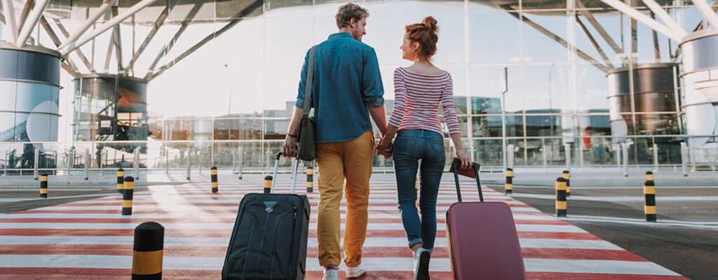 couple at airport with suitcases after travel