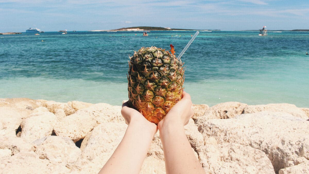 hands holding drink in pineapple