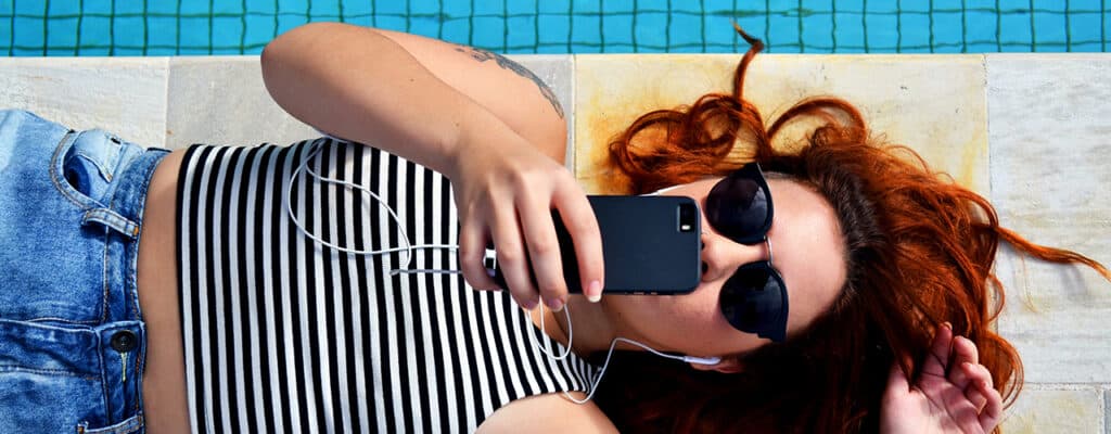 girl by pool with phone
