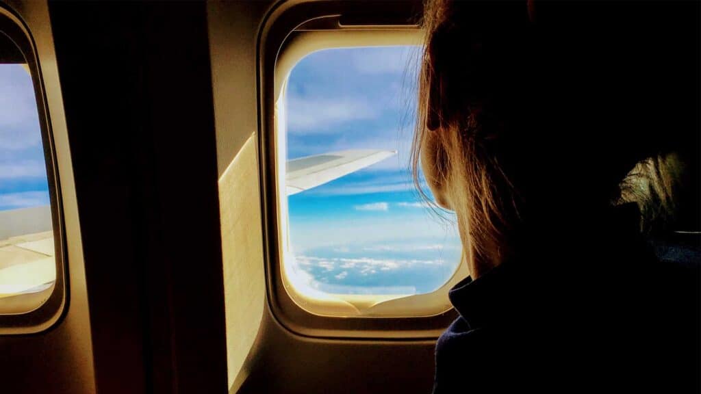 woman looking out window on plane