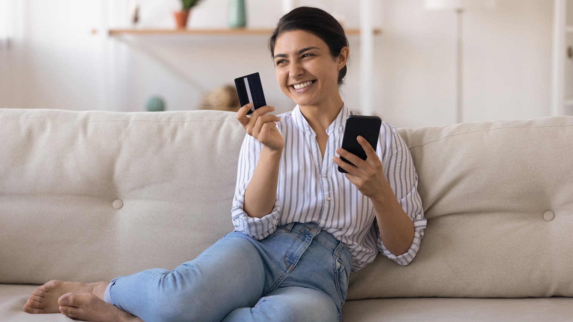 woman on couch checking card rewards