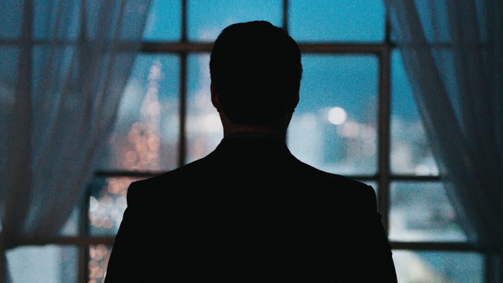 silhouette of man in front of city window