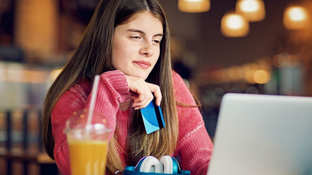 teen using credit card in coffee shop