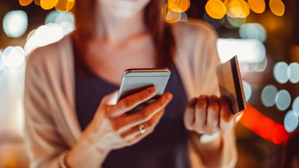 woman looking at card and phone