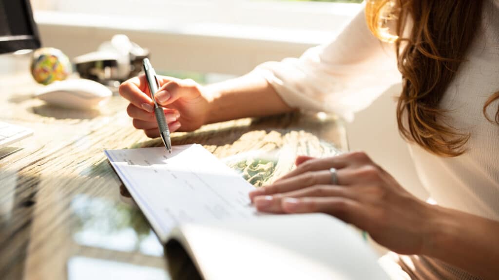 woman writing a check at her desk
