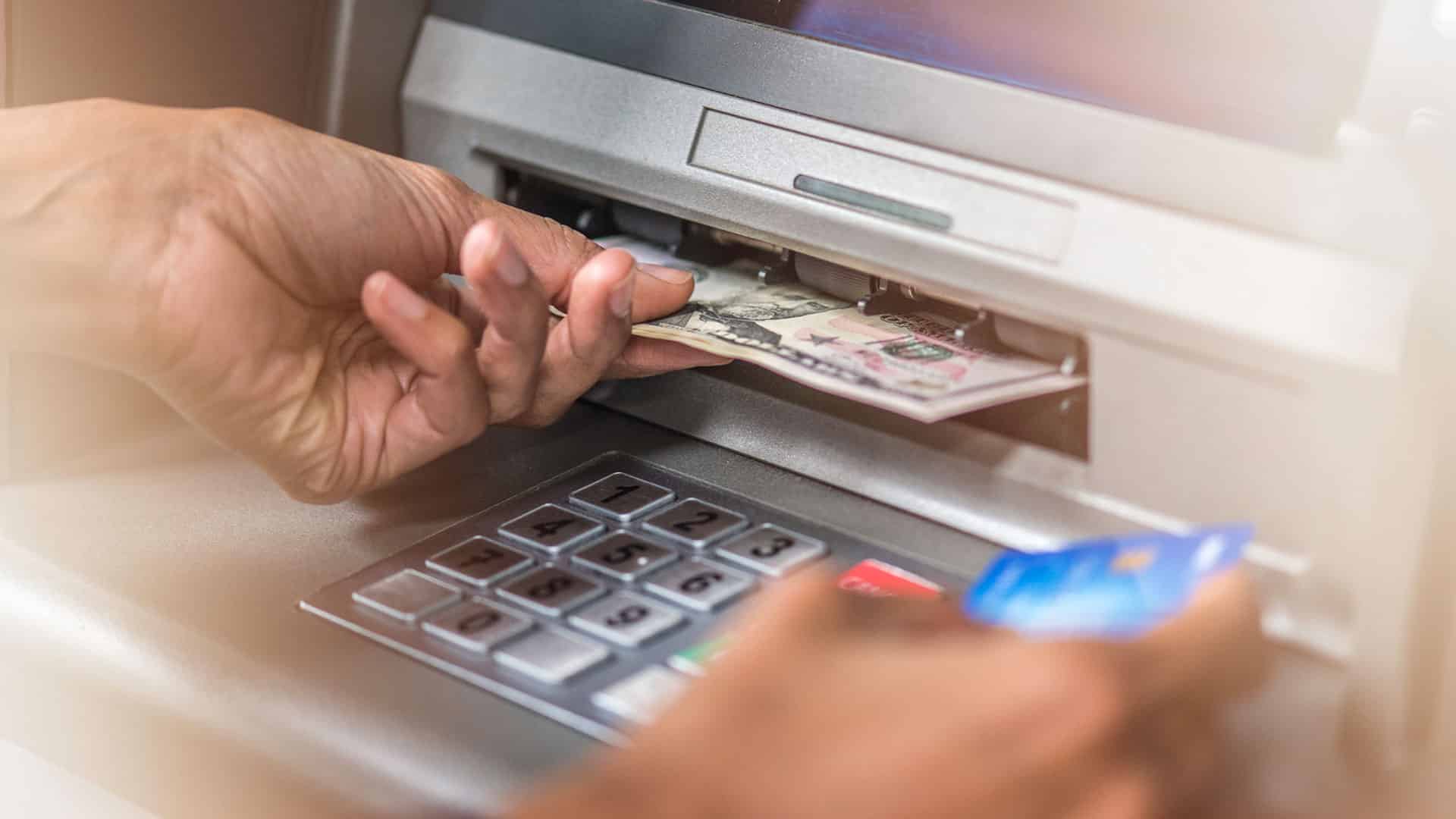 hand getting money from atm
