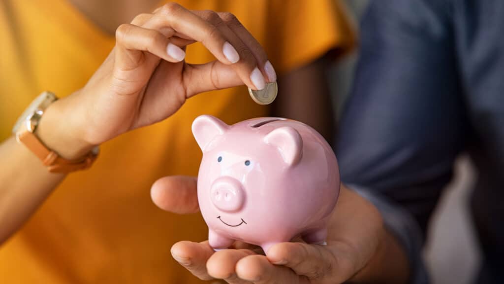 couple holding piggy bank with coin