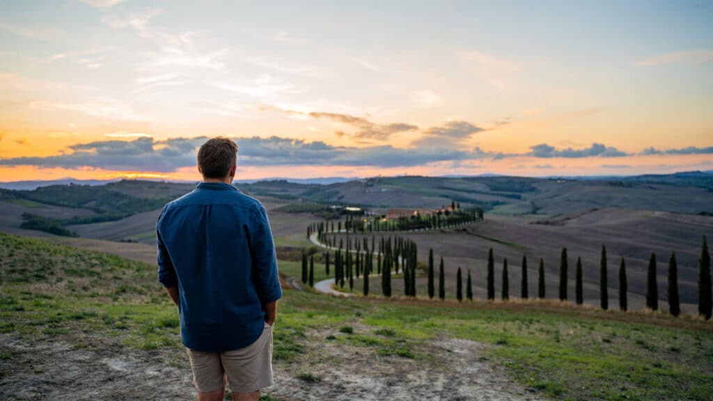 man enjoying sunset over italian countryside