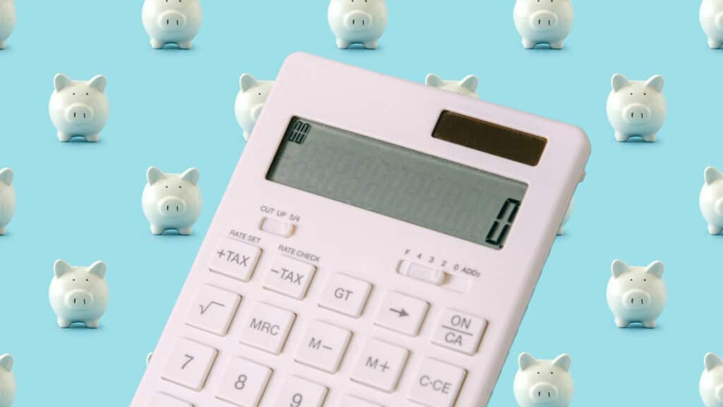 calculator on background of piggy banks