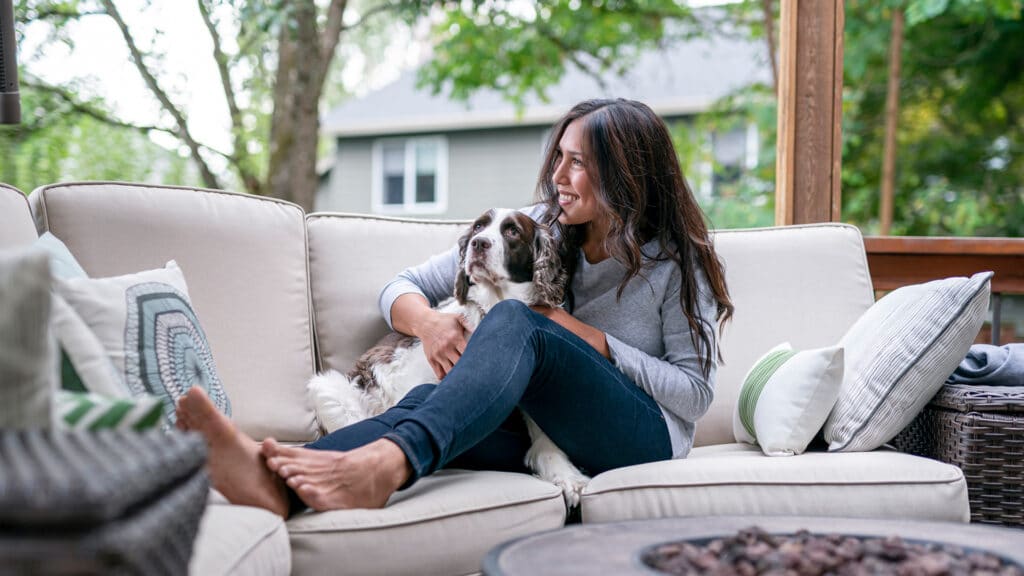 woman in backyard with dog on couch