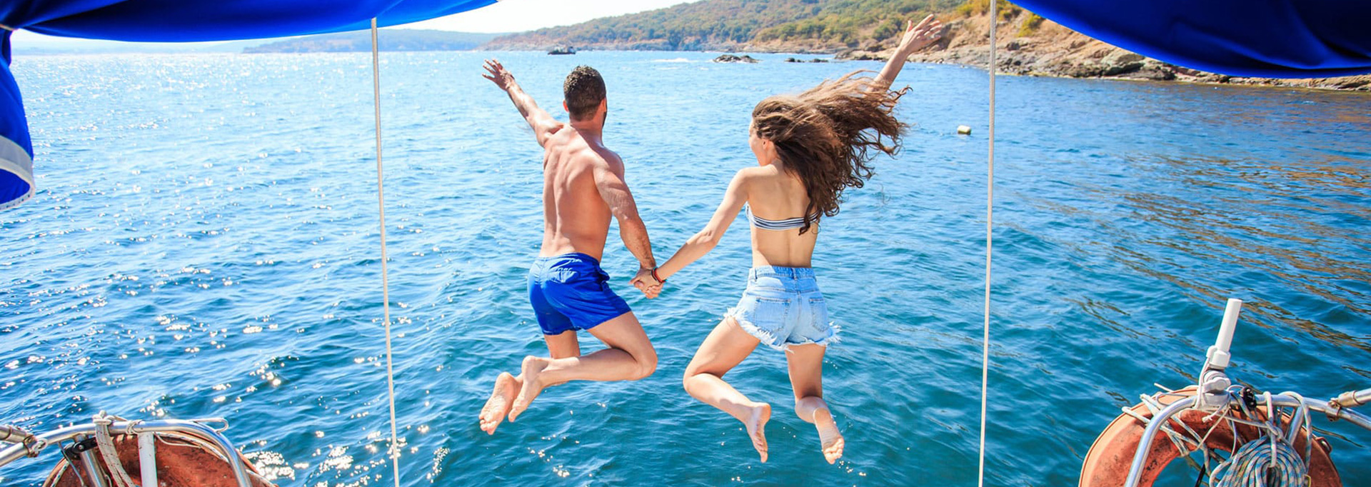couple jumping off sailboat
