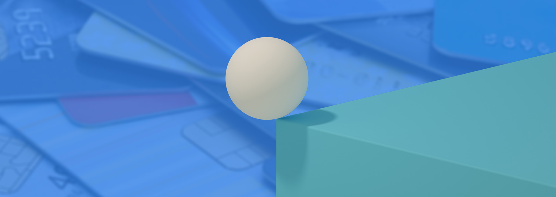 ball on edge of block over credit card background