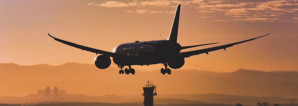 airplane landing at airport during sunset