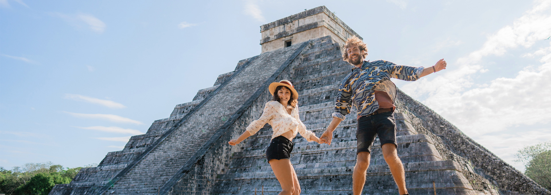 couple jumping at Chichen Itza in Mexico