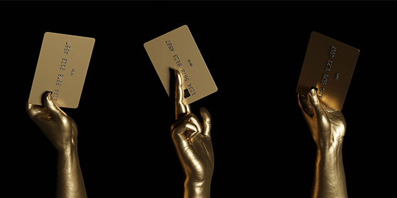 Gold credit cards in gold hands